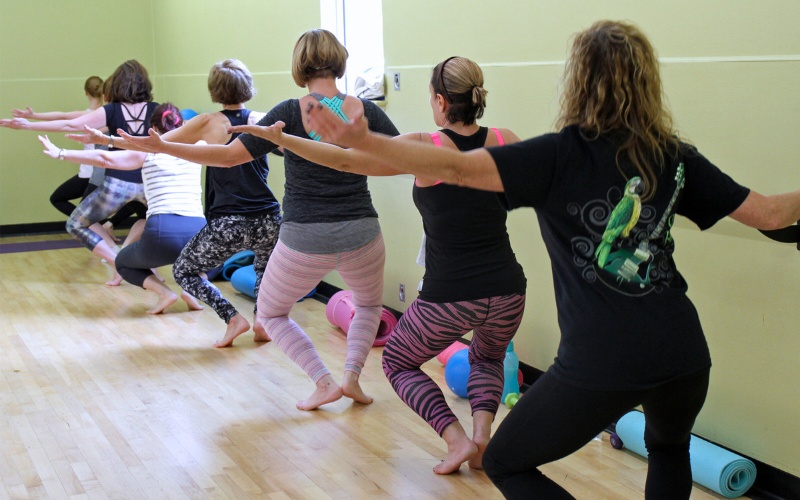 gym members hold a balanced pose during a barre group fitness dance class at a furlong gym near me