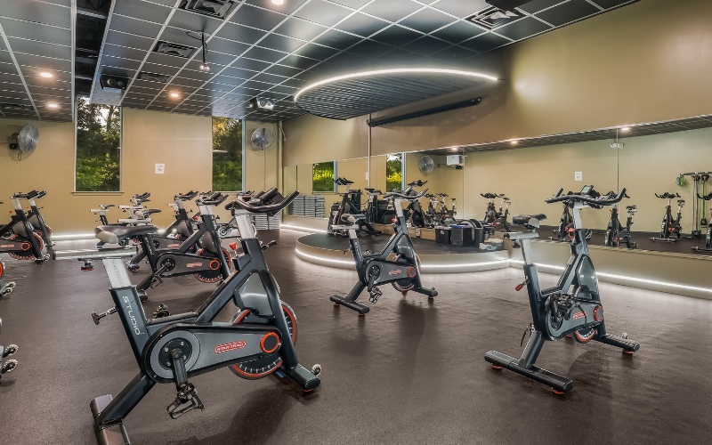 a spacious group fitness spinning studio with cycling machines at a furlong gym