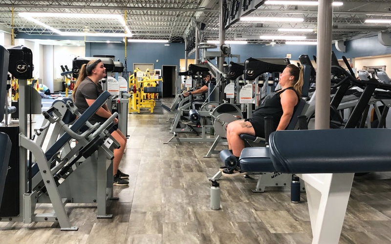 gym members work use leg machines for strength training at a furlong gym