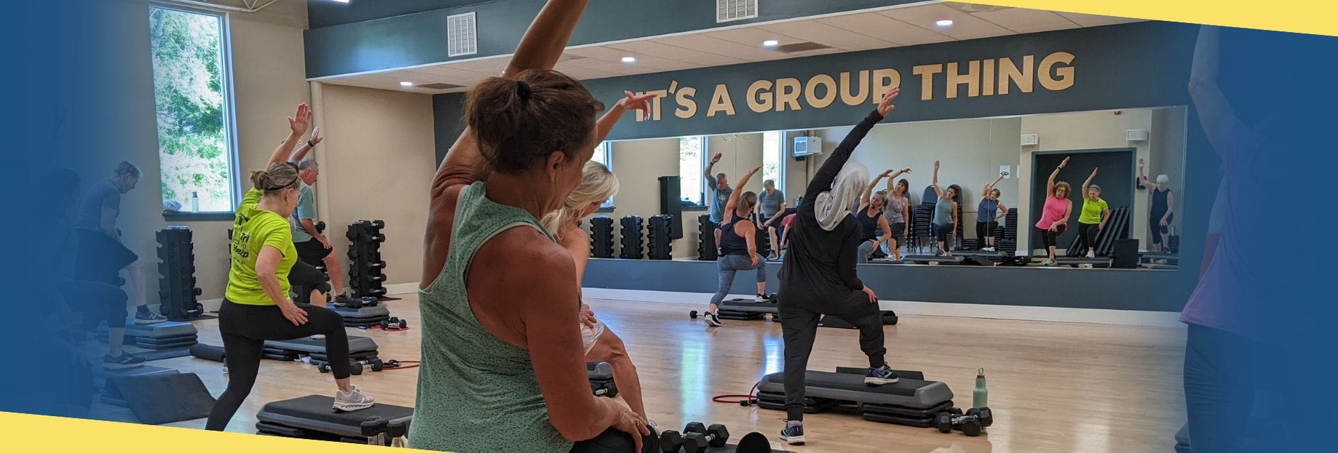 Group fitness class at Cornerstone Clubs Doylestown promoting the November offer of $0 enrollment with a food donation, featuring members stretching together in a bright studio.