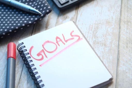 Image of a notebook with the word goals written on the page.