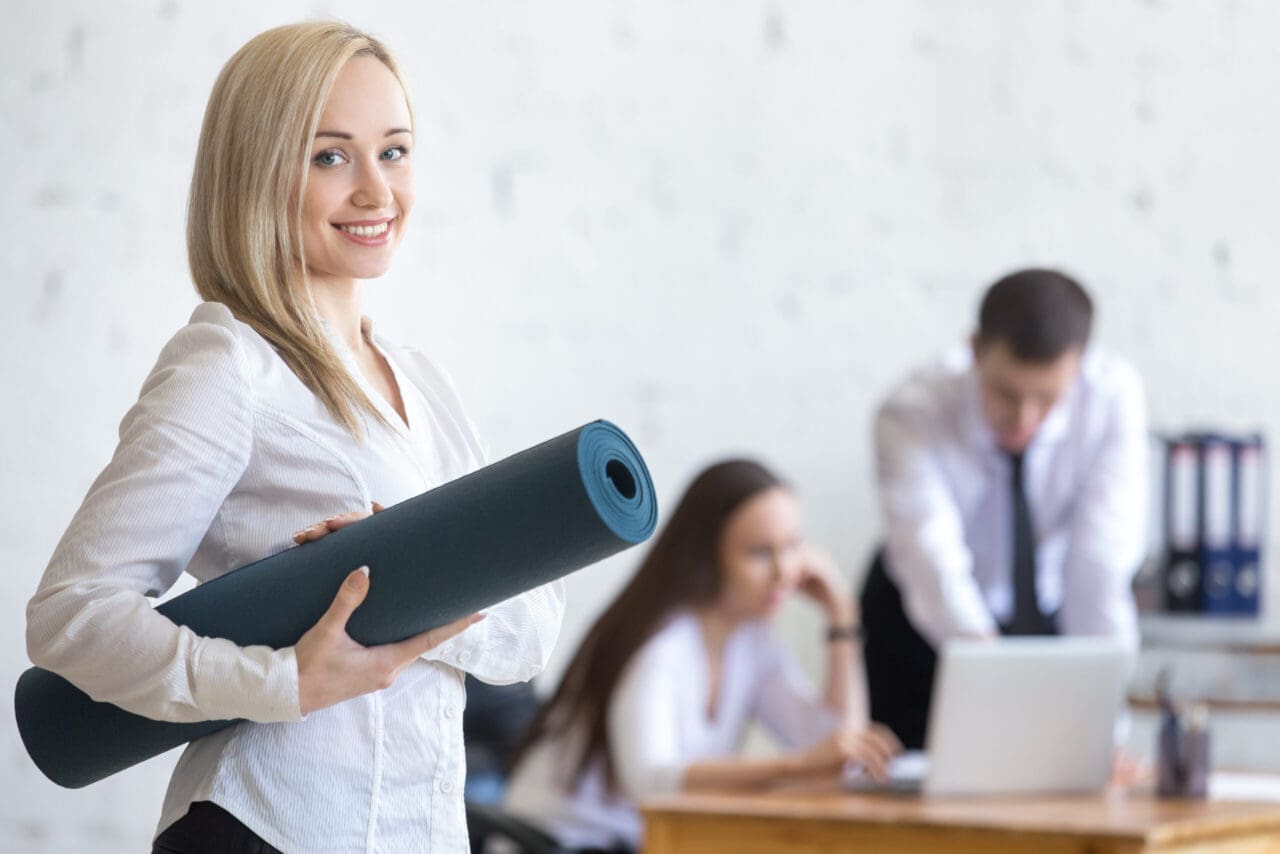 Woman holding yoga mat at Cornerstone gyms