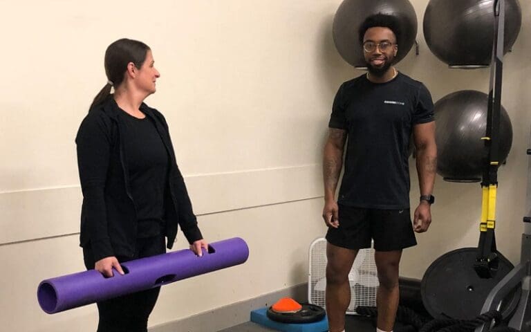 a certified personal trainer works with a gym member at a bucks county cornerstone health and fitness gym