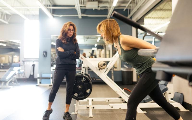 a gym member works with a personal trainer at cornerstone gym near me