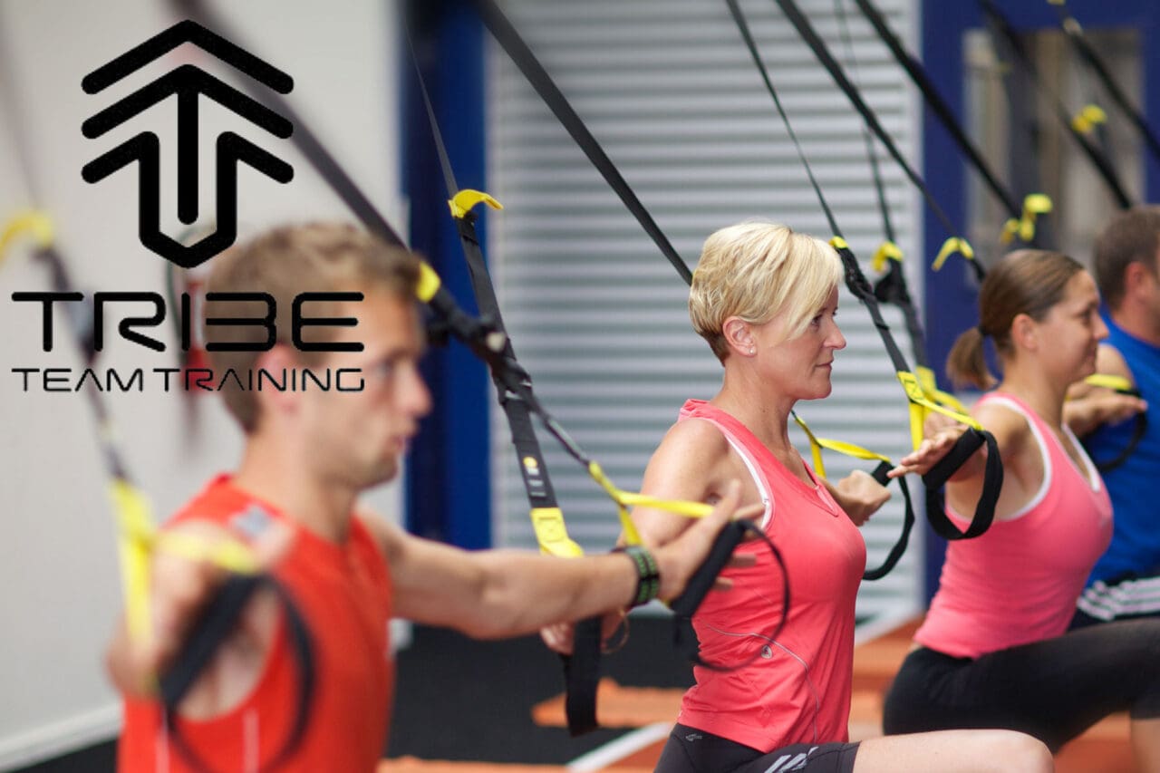 A group of people using TRX straps during fitness training.