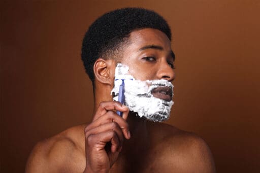Man shaving his face.